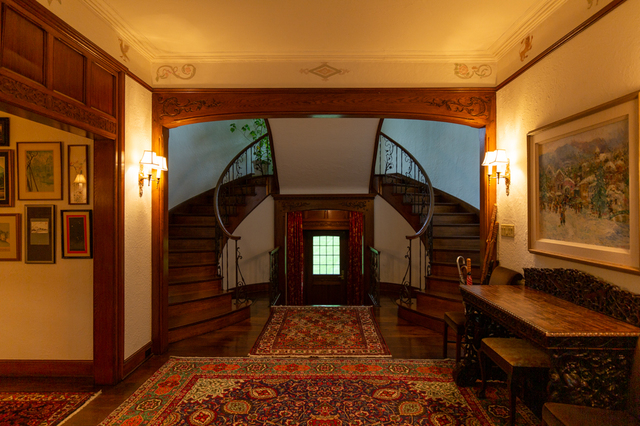 Contemporary photograph of entrance hall and winding staircase to second floor flanking the original main entrance